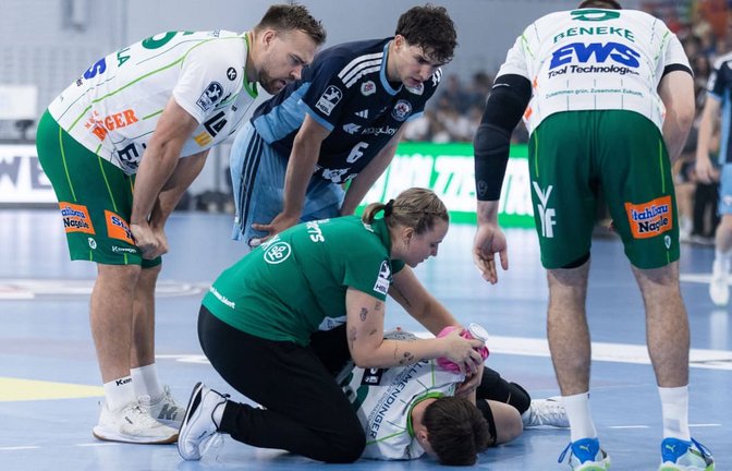 Göppingens Spielmacher Ole Pregler liegt in der Sporthalle Hamburg am Boden und wird an seiner Schulter von Frisch-Auf-Physiotherapeutin Katharina Leßig behandelt.<span class='image-autor'>IMAGO/Eibner</span>