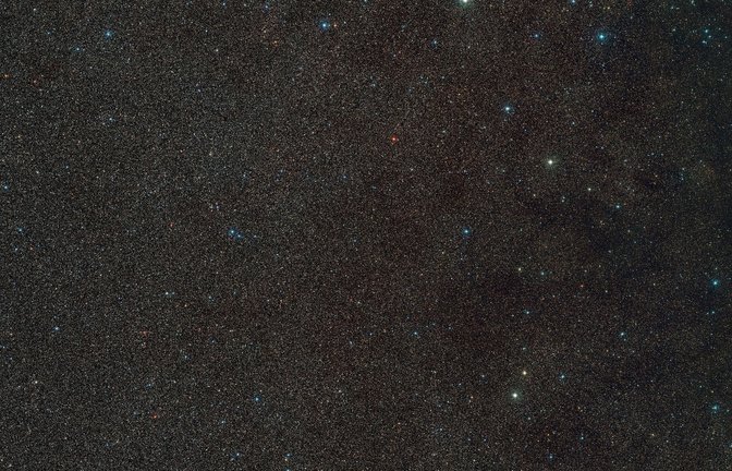 Das Handout zeigt einen Weitwinkelausschnitt der Umgebung von "Gaia BH3", dem massereichsten stellaren schwarzen Loch in unserer Galaxie. Das schwarze Loch selbst ist hier nicht sichtbar, aber der Stern, der es umkreist, befindet sich in der Mitte des Bildes.<span class='image-autor'>Foto: D. De Martin./ESO/Digitized Sky Survey 2./dpa</span>