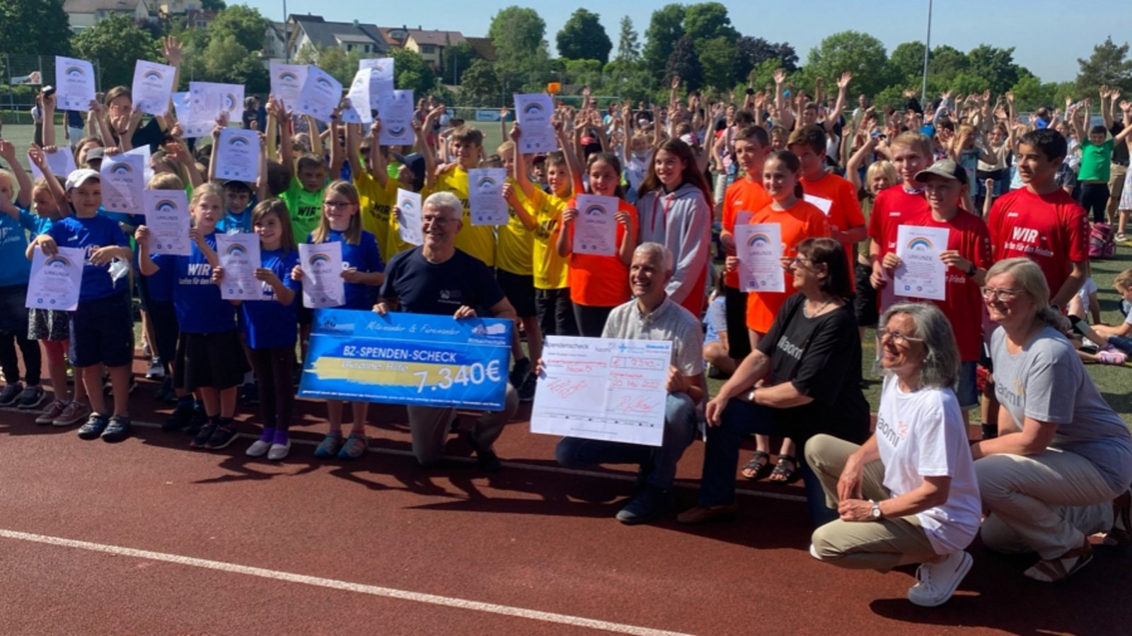 Matthias Rose, Referent für Flüchtlingsarbeit (Vierter von rechts, vorne) bei der Scheckübergabe auf dem Sportplatz in Hohenhaslach. Foto: p Matthias Rose, Referent für Flüchtlingsarbeit (Vierter von rechts, vorne) bei der Scheckübergabe auf dem Sportplatz in Hohenhaslach. Foto: p
