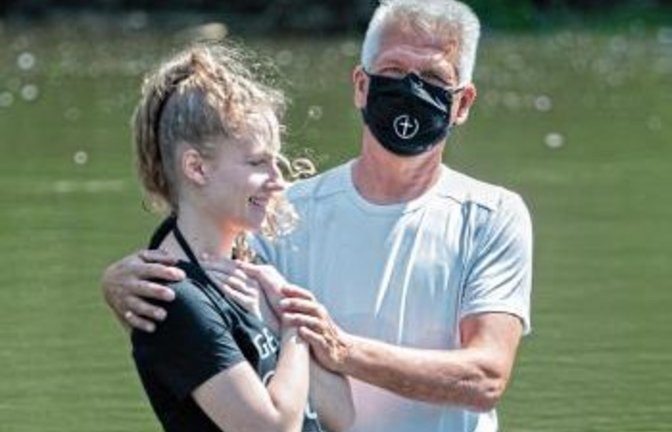 Pastor Dietrich Ebeling tauft Tabea Roersch in der Enz. Foto: Henkel
