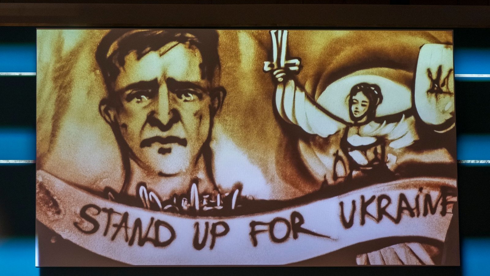 Der 69. Bundespresseball in Berlin stand ganz im Zeichen des Krieges in der Ukraine. Eine Künstlerin malte ein Sandbild, das den ukrainischen Präsidenten zeigen soll.Foto: Monika Skolimowska/dpa
