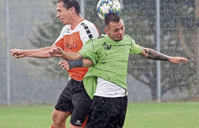 Kapitäne beim Kopfballduell: Iptingens Benjamin Rapp (links) und Walheims Robin Prüller kämpfen bei strömendem Regen um den Ballbesitz. Foto: Küppers