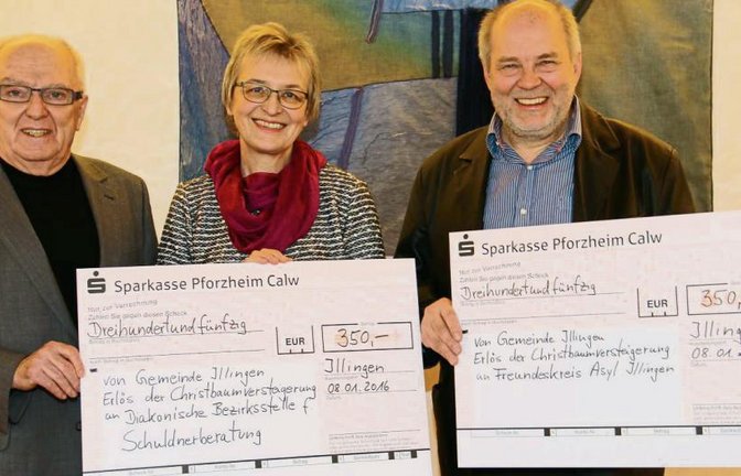 Scheuermann (links) überreicht als Gemeindevertreter Symbolschecks an die Vertreter der Diakonie und des Arbeitskreises Asyl. Foto: Rücker