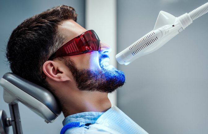 Beim Bleaching der Zähne in der Praxis wird ein hochdosiertes Gel, das Wasserstoffperoxid enthält,  aufgetragen und oft zusätzlich mit einer speziellen Lampe erwärmt<span class='image-autor'>Foto: HBS - stock.adobe.com</span>