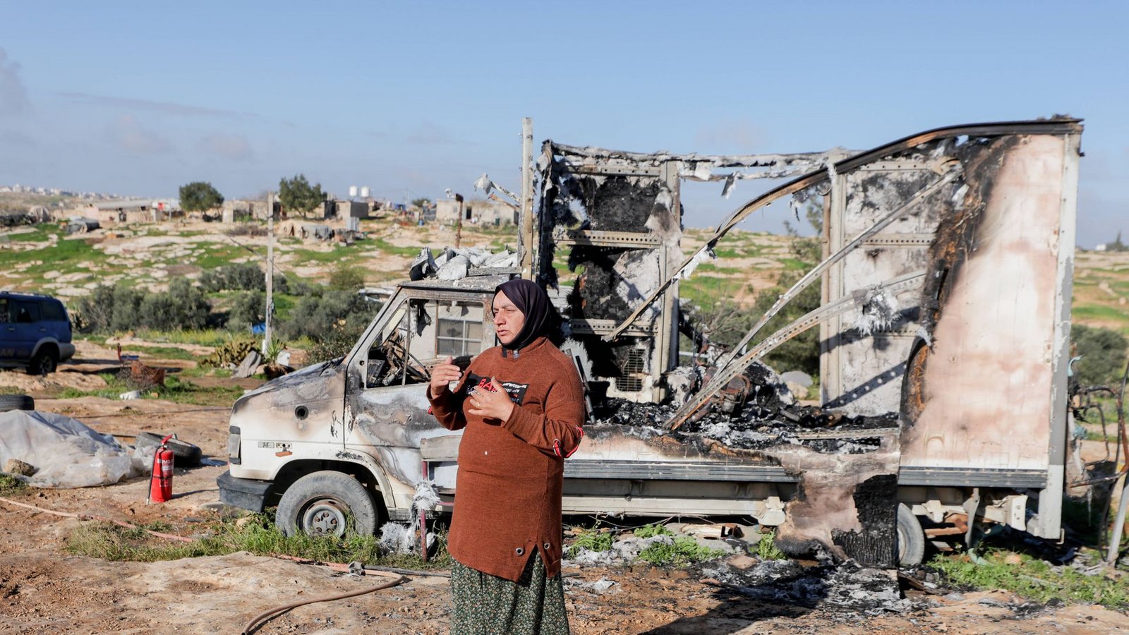 Eine Bewohnerin steht neben einem ausgebrannten Fahrzeug im Dorf Susya bei Hebron im besetzten Westjordanland. Israelische Siedler sollen Ende Februar dort Zelte und Autos angezündet haben.Foto: IMAGO/Middle East Images/IMAGO/Mosab Shawer Eine Bewohnerin steht neben einem ausgebrannten Fahrzeug im Dorf Susya bei Hebron im besetzten Westjordanland. Israelische Siedler sollen Ende Februar dort Zelte und Autos angezündet haben.Foto: IMAGO/Middle East Images/IMAGO/Mosab Shawer