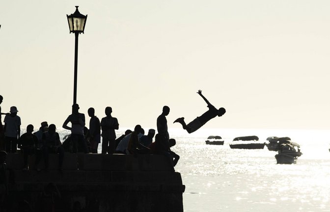 Sprung ins Ungewisse: Spielende Kinder am Meer von Sansibar. Von hier verschlägt es den Protagonisten des Romans nach England.<span class='image-autor'>Foto: IMAGO/robertharding/IMAGO</span>