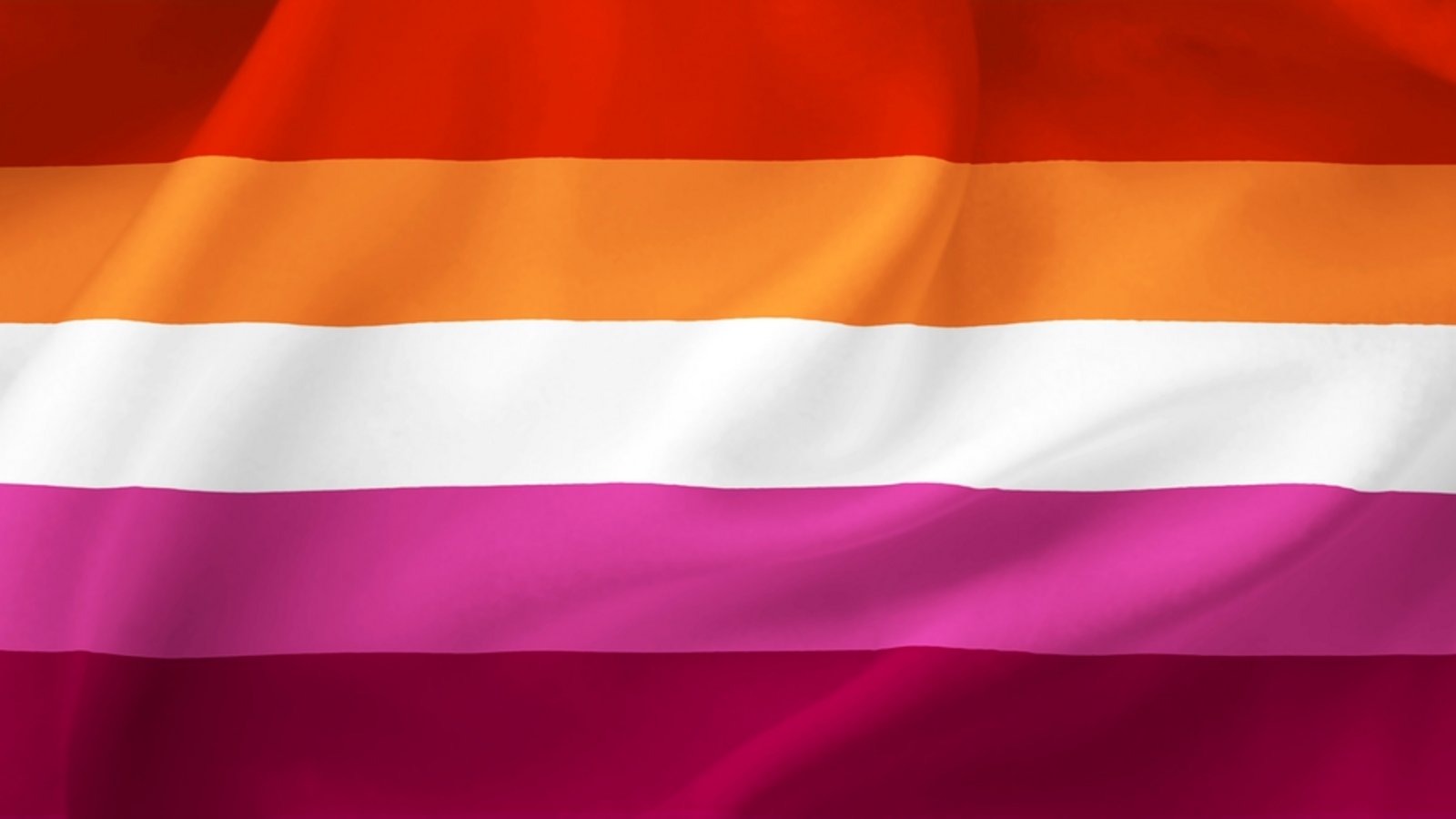 Flagge der lesbischen Frauen: Die Lesbian Pride Flagge zeigt – je nach Ausführung – fünf bis sieben horizontale Streifen in Farben von dunklem Orange über Weiß bis hin zu dunklem Pink. Die verschiedenen Farben stehen für unterschiedliche Aspekte der lesbischen Erfahrung: Gender-Nonkonformität, Unabhängigkeit, Gemeinschaft, einzigartige Beziehungen zum Frausein, Gelassenheit und Frieden, Liebe und Sex und Weiblichkeit.Foto: Uliana26/Shutterstock