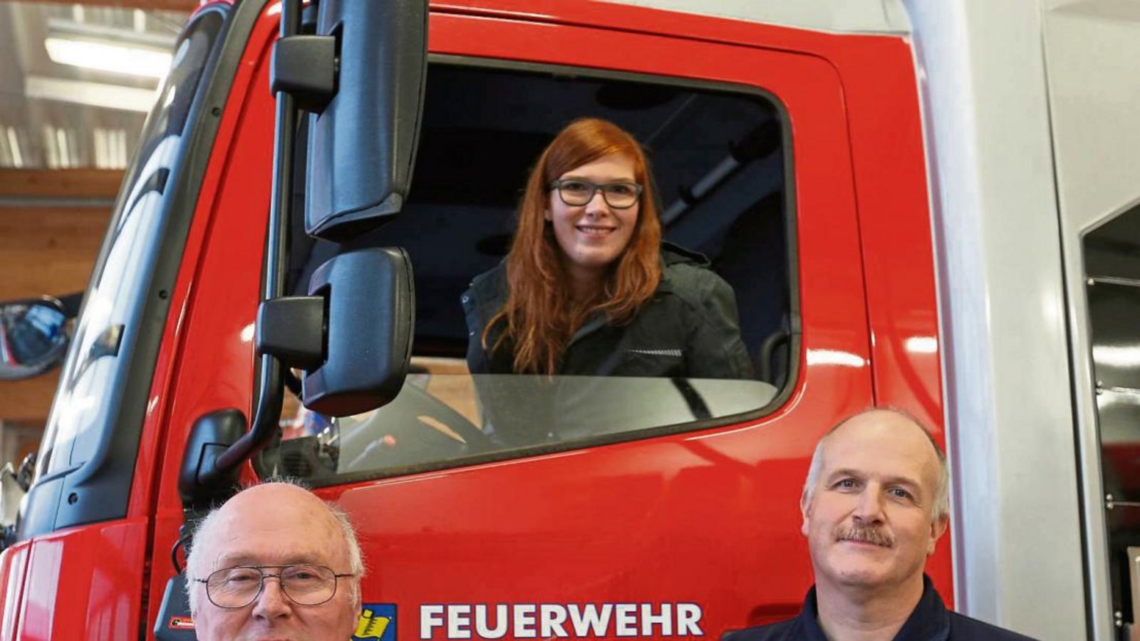 Drei Generationen in einer Feuerwehr: Opa Willi, Vater Gerd und Mareike Schmidt am Illinger Löschfahrzeug. Foto: Küppers