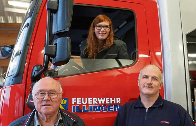 Drei Generationen in einer Feuerwehr: Opa Willi, Vater Gerd und Mareike Schmidt am Illinger Löschfahrzeug. Foto: Küppers