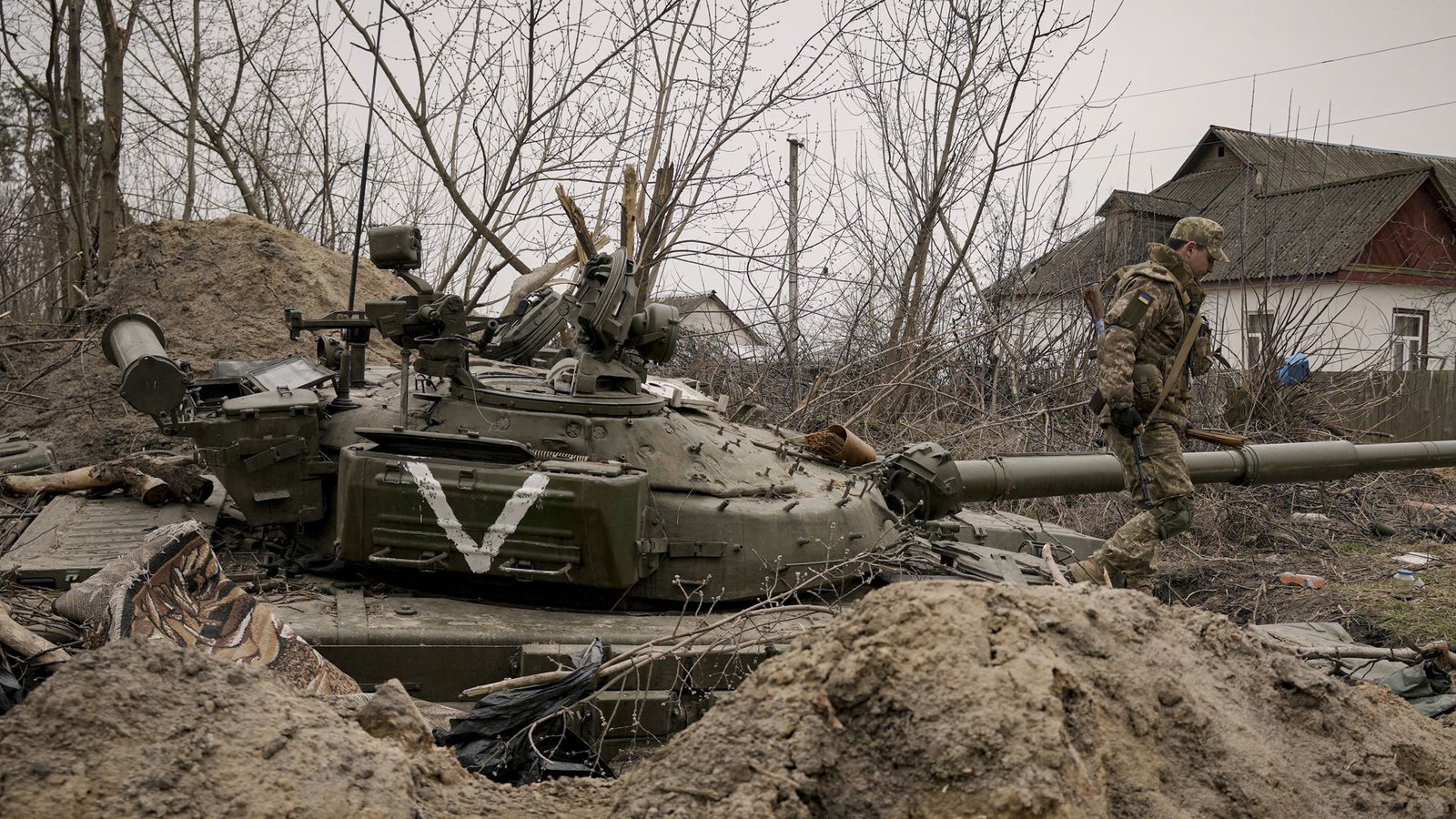 Ein ukrainischer Soldat geht an einem verlassenen Panzer der russischen Armee in der Stadt Andrijiwka  vorbei.Foto: AP/dpa/Vadim Ghirda