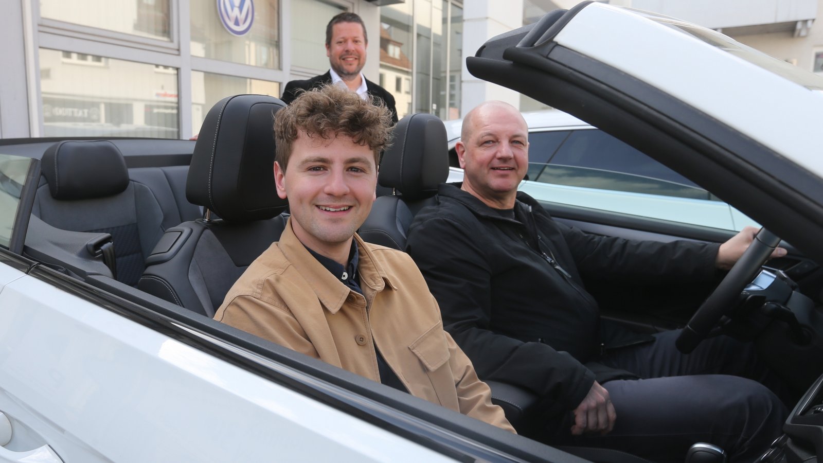 Gewinner Miguel Rapp (vorne) und sein Vater Harald Rapp nehmen bei Gunnar Bäuerle vom Sevo-Vertrieb das Cabrio für ihren Wochenendtrip nach München in Empfang.  Foto: Küppers