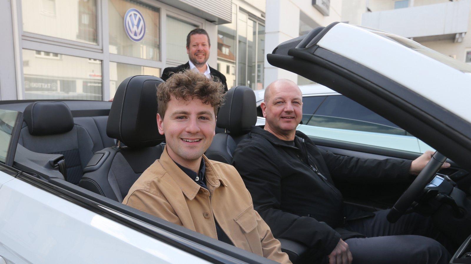 Gewinner Miguel Rapp (vorne) und sein Vater Harald Rapp nehmen bei Gunnar Bäuerle vom Sevo-Vertrieb das Cabrio für ihren Wochenendtrip nach München in Empfang.  <span class='image-autor'>Foto: Küppers</span>