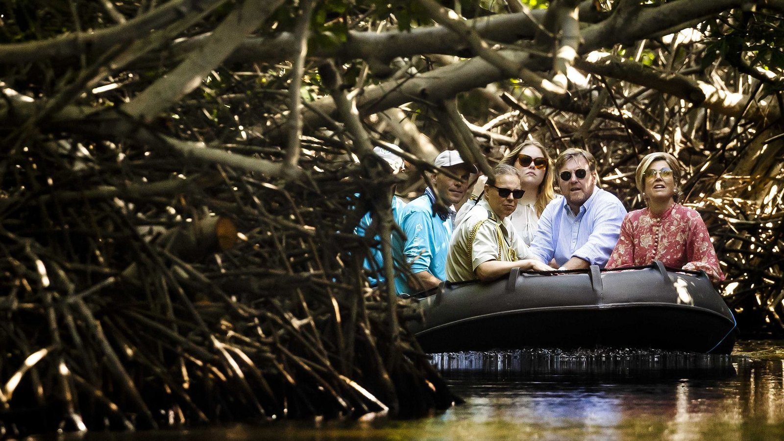 König Willem-Alexander (2.v.r.), Königin Maxima (r) und Kronprinzessin Amalia fahren in einem Schlauchbot durch die Mangrovenwälder bei Sorobon.Foto: Remko De Waal/ANP/dpa
