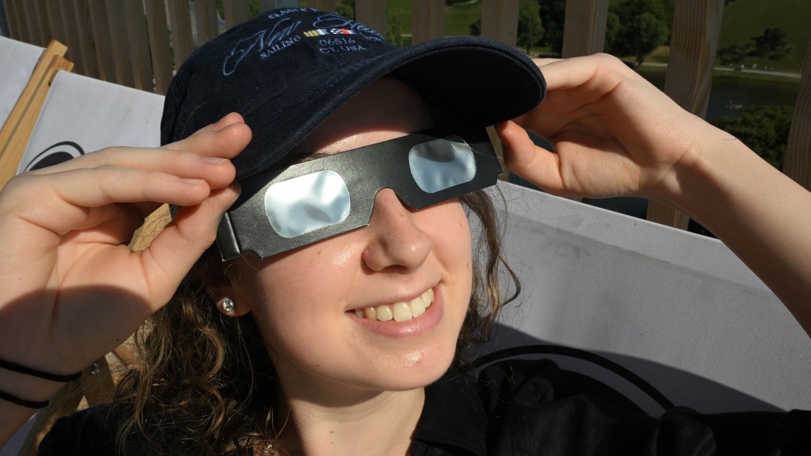 Antonia sitzt mit einer Schutzbrille in einem Liegestuhl auf dem SAYAQ  Adventure Tower im Münchner Olympiapark vor der partiellen Sonnenfinsternis. Auch in Teilen Europas, Nordamerikas und anderen Regionen ist dieses Himmelsschauspiel sichtbar. (zu dpa: «Totale Sonnenfinsternis gestartet - ein Millionenspektakel»)Felix Hörhager/dpa