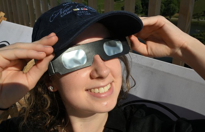 Antonia sitzt mit einer Schutzbrille in einem Liegestuhl auf dem SAYAQ  Adventure Tower im Münchner Olympiapark vor der partiellen Sonnenfinsternis. Auch in Teilen Europas, Nordamerikas und anderen Regionen ist dieses Himmelsschauspiel sichtbar. (zu dpa: «Totale Sonnenfinsternis gestartet - ein Millionenspektakel»)<span class='image-autor'>Felix Hörhager/dpa</span>