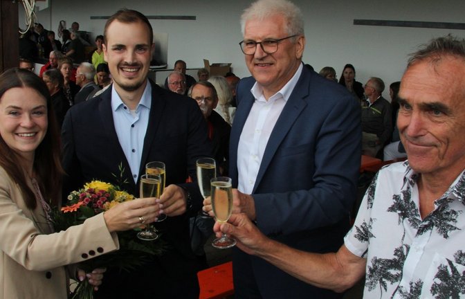 Fabienne und Ron Keller stoßen mit Bürgermeister-Stellvertreter Gerd Maisch und dem ehrenamtlichen stellvertretenden Bürgermeister Erich Bannert (von links) an.