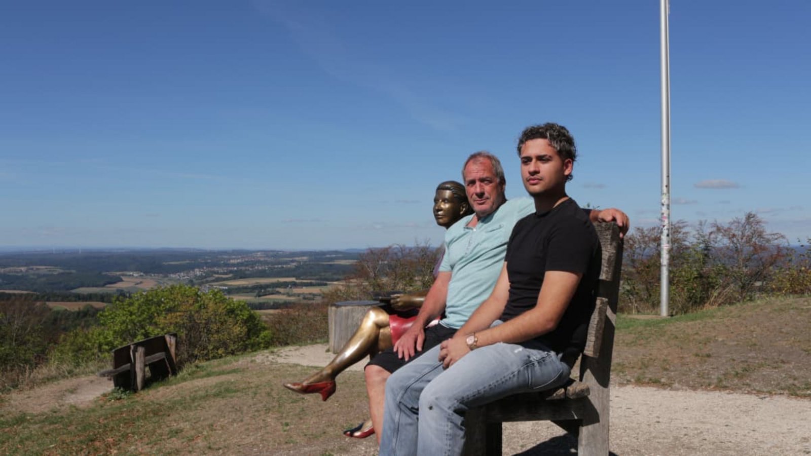 Ein Job mit Aussicht. Restaurantbesitzer Andreas Schweickert mit seinem Auszubildenden Nour Augustin neben einer Bronzeskultur auf dem Hohenstaufen bei Göppingen.Annika Grah