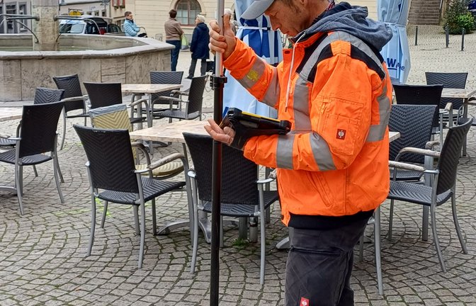 Von der Vermessungsabteilung des Tiefbauamts ist Marco Böckle auf dem Vaihinger Marktplatz unterwegs, um ein paar Standpunkte zum Beispiel für Schirmständer oder Bäume zu visualisieren – die Marktplatzumgestaltung lässt grüßen.  <span class='image-autor'>Foto: Rücker</span>