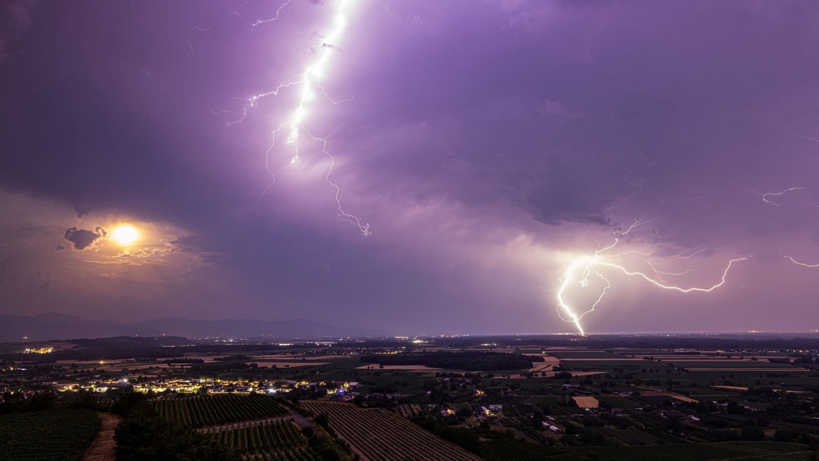 Ein Blitz geht über dem Rheintal nieder während im Vordergrund der Kaiserstuhl zu sehen ist.  (zu dpa: «So ändert sich das Gewitterrisiko im Laufe des Tages»)Philipp von Ditfurth/dpa