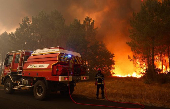 Feuerwehrleute versuchen in der Nähe von Le Porge im Südwesten Frankreichs mit einem Waldbrandlöschfahrzeug, die brennenden Bäume zu löschen.<span class='image-autor'>Romain Perrocheau/AFP/dpa</span>