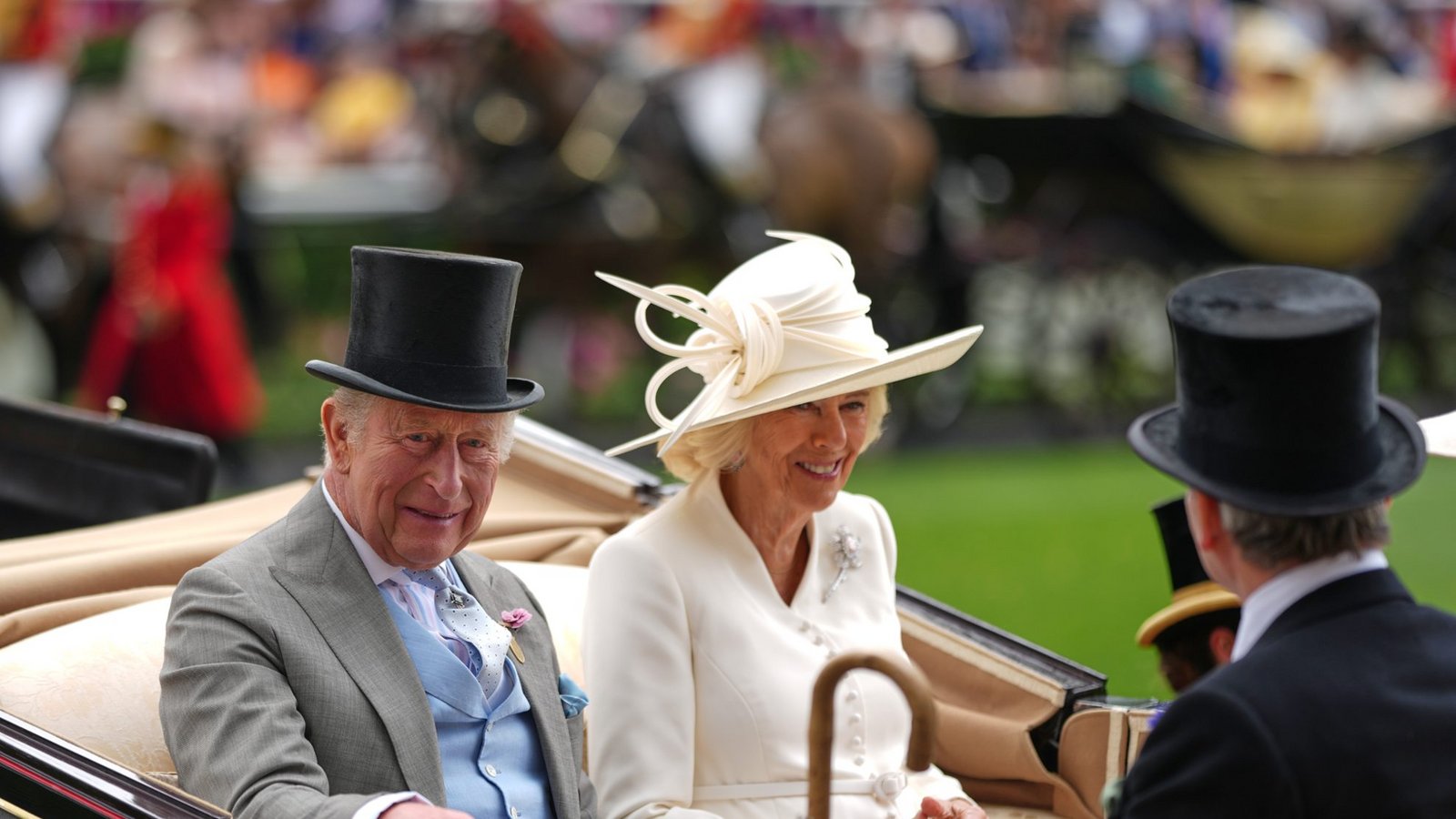 Königin Camilla zeigt am zweiten Tag von Royal Ascot einen cremeweißen Look mit passendem Hut: Der schräg sitzende Kopfschmuck ist mit skulpturalen Schleifen und feinen Stäben verziert, dazu trägt sie ein helles Mantelkleid mit Brosche.Foto: picture alliance/dpa/AP | Alastair Grant