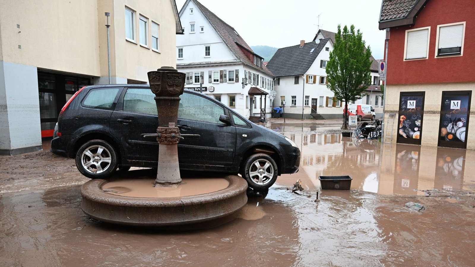 Auf einem Brunnen in Rudersberg (Rems-Murr-Kreis) steht Anfang Juni 2024 ein durch Hochwasser weggespültes Auto.Foto: dpa/Bernd Weißbrod Auf einem Brunnen in Rudersberg (Rems-Murr-Kreis) steht Anfang Juni 2024 ein durch Hochwasser weggespültes Auto.Foto: dpa/Bernd Weißbrod