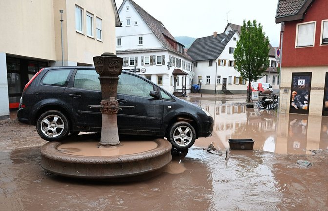 Auf einem Brunnen in Rudersberg (Rems-Murr-Kreis) steht Anfang Juni 2024 ein durch Hochwasser weggespültes Auto.<span class='image-autor'>Foto: dpa/Bernd Weißbrod</span>
