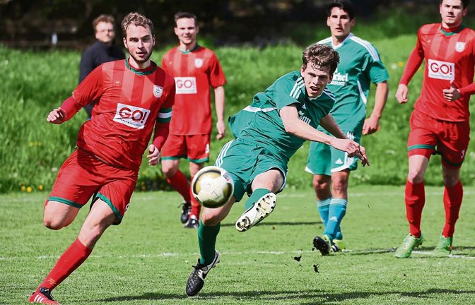 Beim Derby im Hardtwäldle fliegen die Rasenfetzen, wenn Joshua Strasser das Leder unter den Augen des Nussdorfer Kapitäns Heiko Dieterle in Richtung Tor schießt. Foto: Küppers