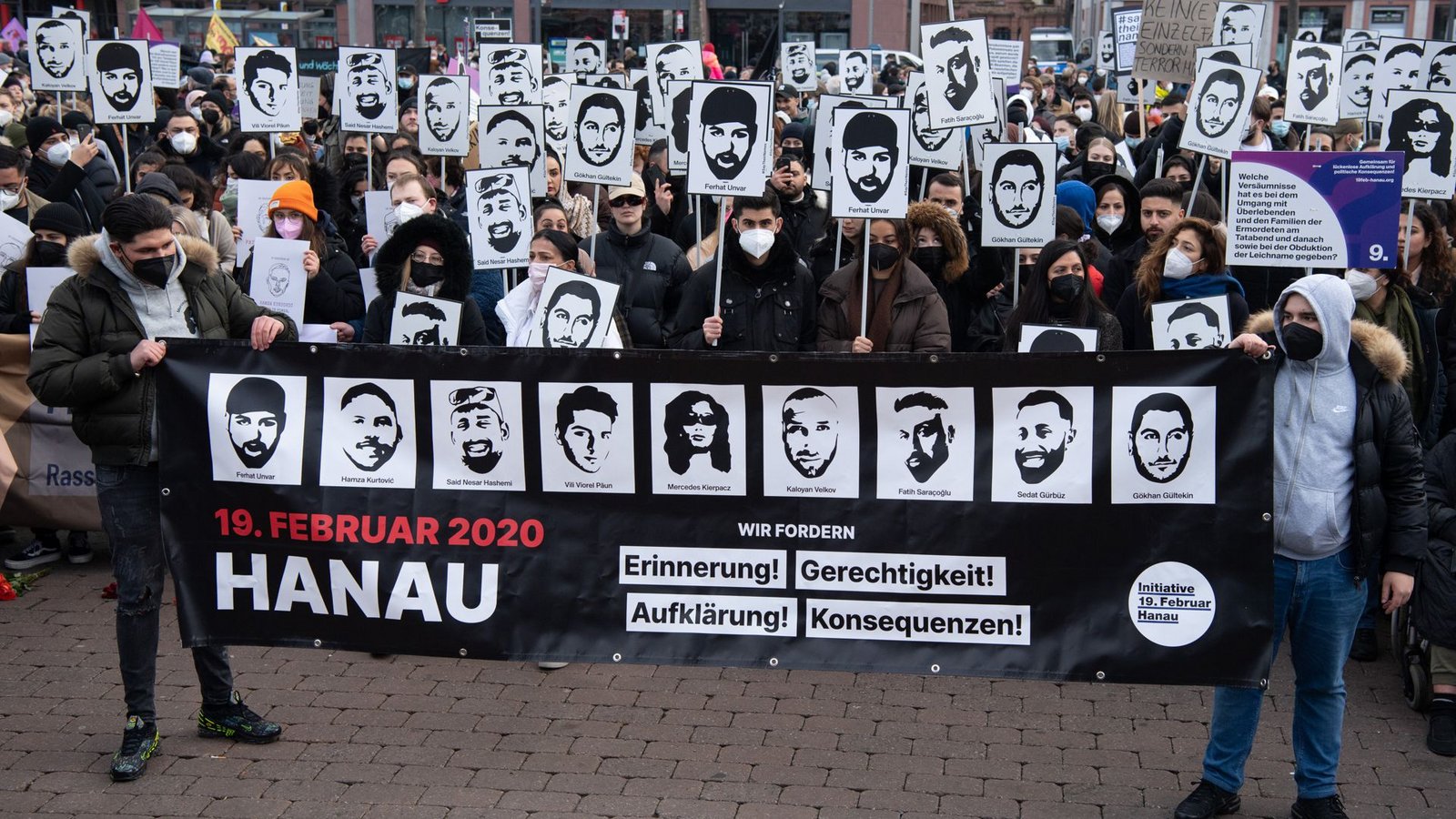 Mit Plakaten und Bildern der Ermordeten erinnern Teilnehmer einer Gedenkveranstaltung 2022 auf dem Hanauer Marktplatz an die Opfer der rassistischen Anschläge in Hanau im Jahr 2020 (Archivfoto).Foto: dpa/Boris Roessler