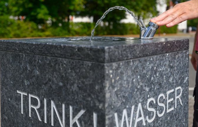 Ein Mann steht an einem Trinkbrunnen. Rund zwei Drittel der Menschen in Deutschland wünschen sich mehr politische Maßnahmen gegen Hitze und Dürre (Symbolfoto).<span class='image-autor'>Patrick Pleul/dpa</span>