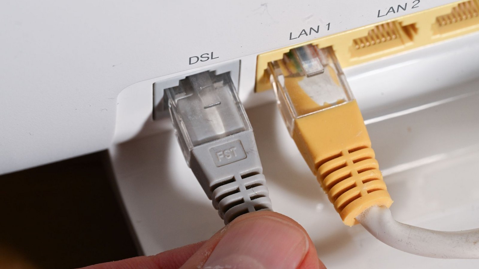 Router mit DSL-Kabel: DSL ist zwar eine alte, aber noch immer dominante Technologie am deutschen Internetmarkt.Foto: Bernd Weißbrod/dpa