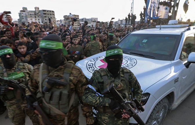 Hamas-Kämpfer eskortieren ein Fahrzeug des Roten Kreuzes in Gaza-Stadt, um israelische Geiseln abzuholen, die  freigelassen wurden.<span class='image-autor'>Foto: dpa/Abed Hajjar</span>