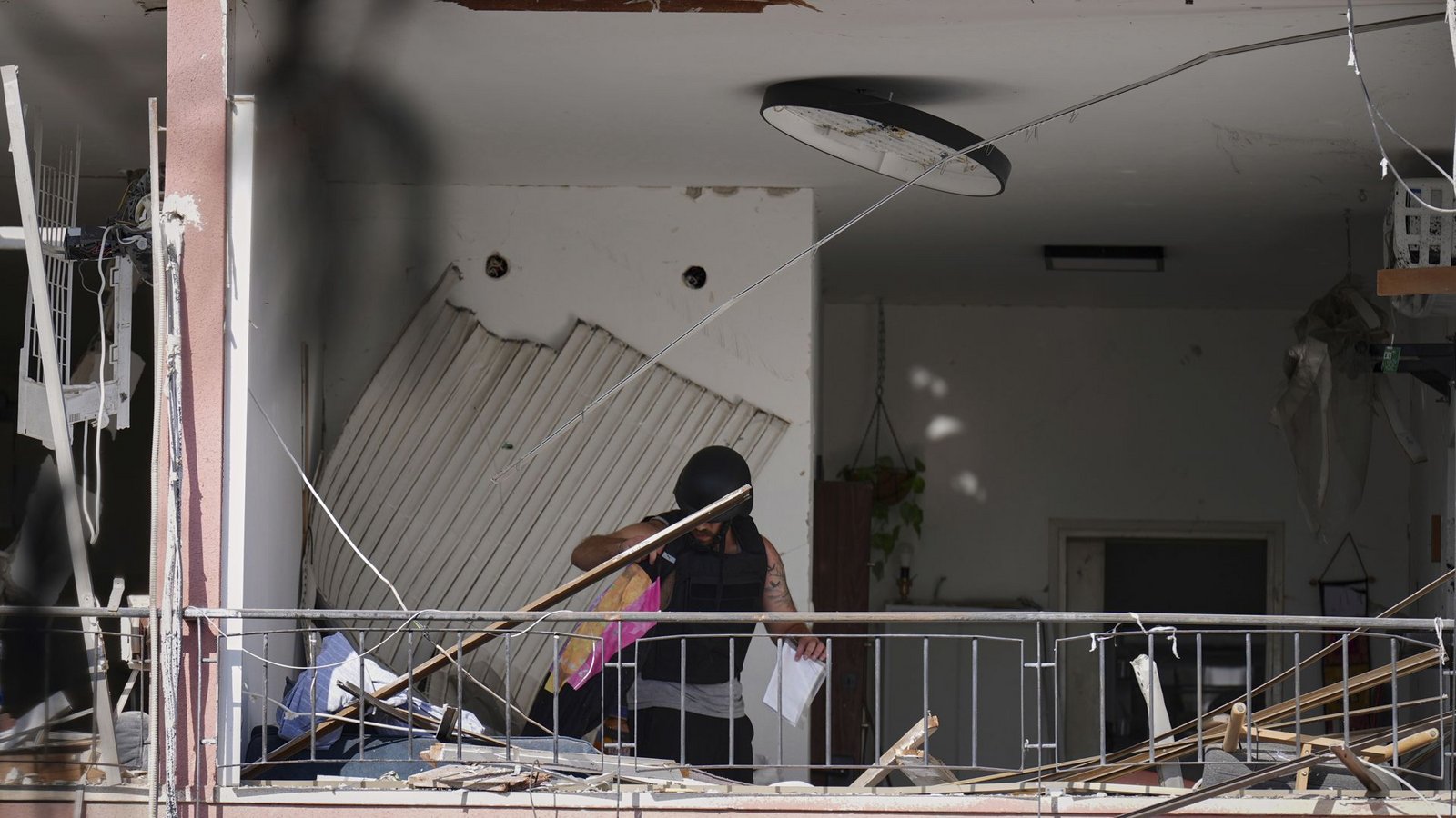 Ein Mann holt in der israelischen Hafenstadt Habseligkeiten aus einer Wohnung, die nach dem Einschlag einer iranischen Rakete beschädigt wurde.Foto: Ariel Schalit/AP/dpa