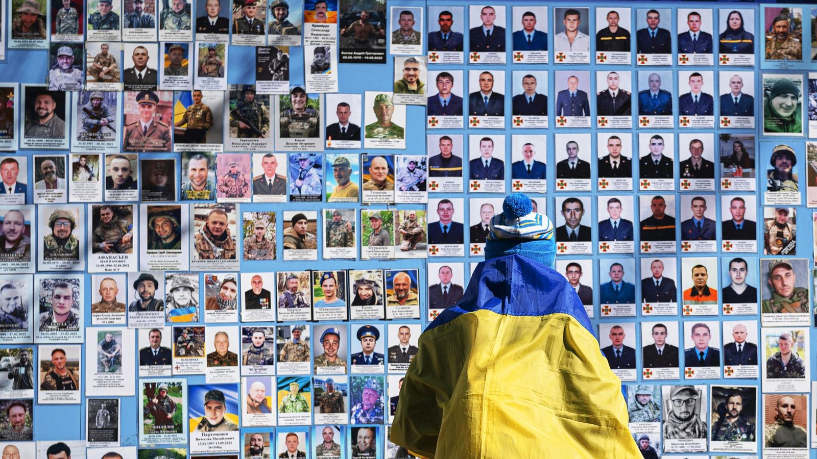 Eine Frau steht in Kiew vor einer Gedenktafel mit Fotos gefallenere Soldaten.Foto: dpa/Andrew Kravchenko