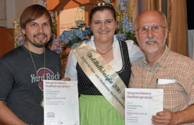 Wolfgang (rechts) und Tobias Fessler erhalten von der Destillatkönigin Anna Schleicher in der Jahnhalle in Weinstadt-Endersbach ihre Goldmedaillen.  Foto: p