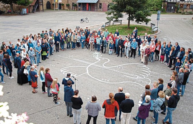 Etwa 170 Menschen umrahmen das Symbol der Friedentaube im Maulbronner Klosterhof.  Foto: Filitz