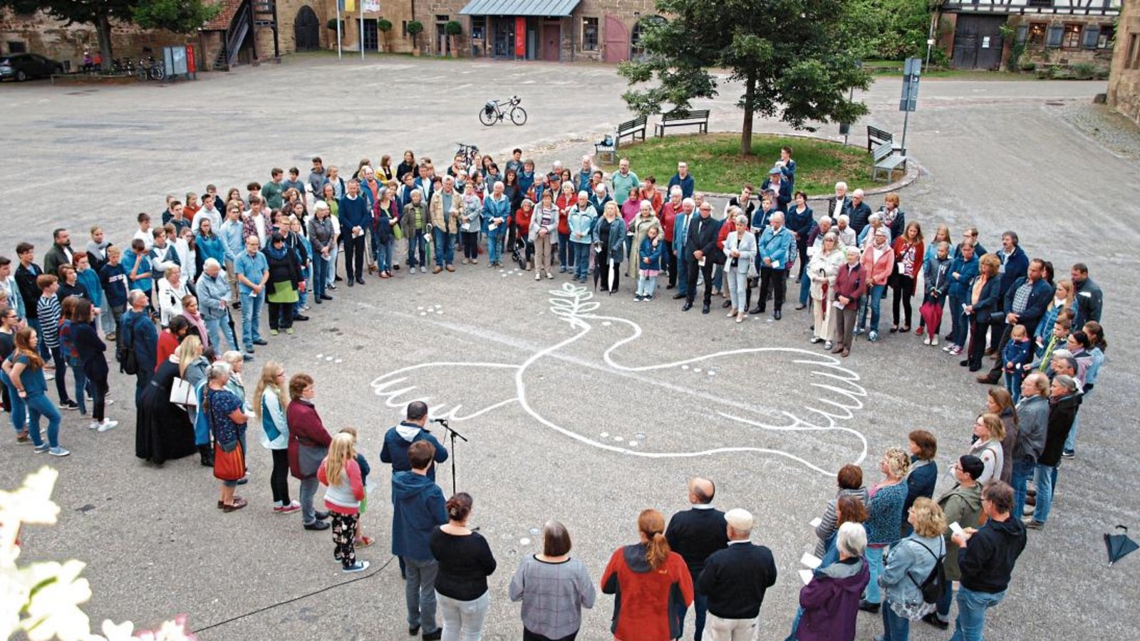 Etwa 170 Menschen umrahmen das Symbol der Friedentaube im Maulbronner Klosterhof.  Foto: Filitz