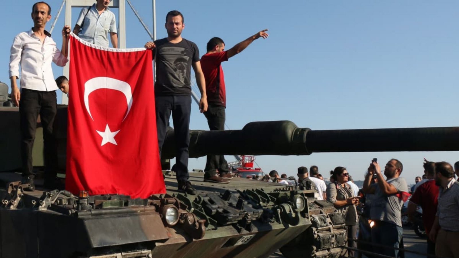 Türkische Polizisten und Anhänger von Präsident Erdogan stehen nach dem gescheiterten Putsch mit einer türkischen Flagge auf einem Panzer auf der Bosporusbrücke. Bei dem Putschversuch vom 15. Juli 2016 waren mehr als 200 Menschen getötet und mehr als 2000 verletzt worden (Archivfoto).Str/EPA/dpa