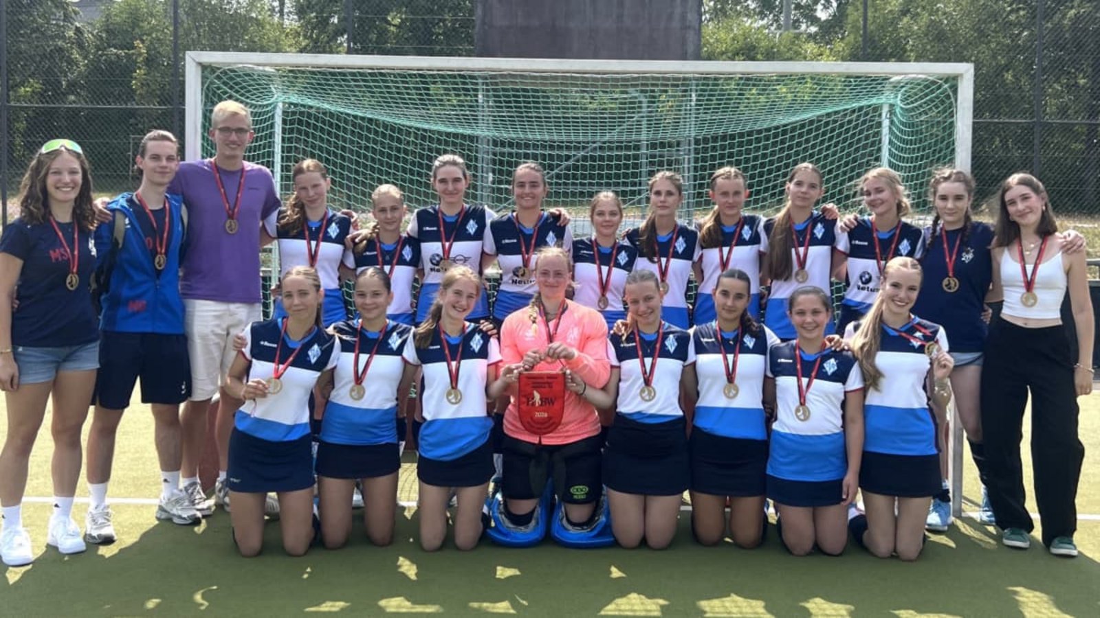 U18-Verbandsligameister: Über Wimpel und Medaillen freuten sich Betreuerin Marie Schäfer, die Trainer Moritz Ostermeier und Mikka Ortner sowie Franziska Dravoj, Johanna Schmid, Hannah Dold, Ida Lauinger, Eva Schneider, Elly Seidel, Fabienne Hess, Lana Bela, Fien Lauteslager, Mathilde Beißner und Ariane Bihler (stehen von links) sowie Milla Lütgenau, Emma Sachs, Nelli Renner, Sina Müller, Naemi Kob, Magdalena Himmel, Katharina Stäbler und Leni Aberle (vorne von links). Auf dem Foto fehlen Mara Renner, Marjam Bertal und Feli Dunz..privat