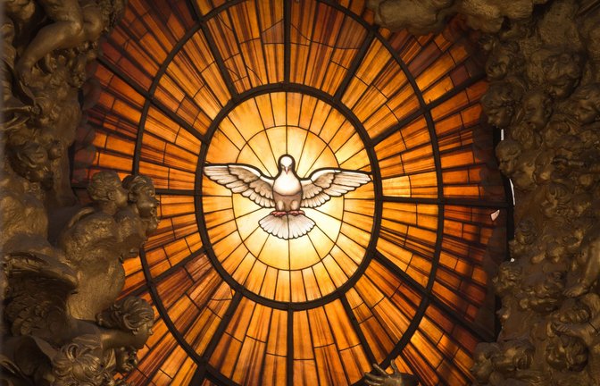 Den Heiligen Geist kann man nicht sehen. Stattdessen wird er häufig durch eine Taube symbolisiert wie bei dieser Darstellung auf einem  Kirchenfenster im Petersdom in Rom.<span class='image-autor'>Foto: dpa/Michael Kappeler</span>