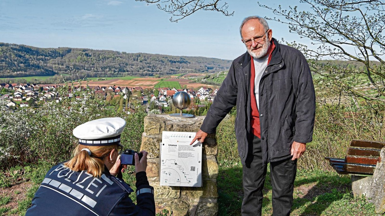 Karl-Heinz Böckle zeigt der Polizei den Schaden am Uranus-Nachbau. Es ist nicht die erste Beschädigung am Planetenweg.  Foto: Kalb