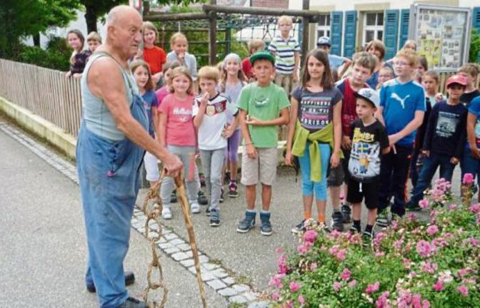 Willy Böhringer zeigt den Roßwager Grundschülern, wie eine Wengerter-Peitsche funktioniert. Foto: Kniep