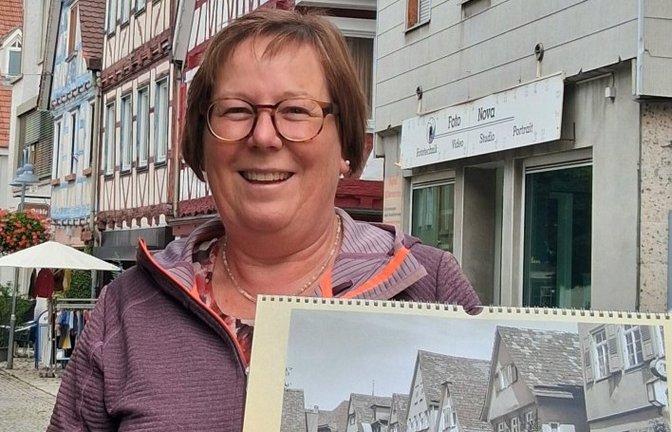 Damals und heute: Stadtarchivarin Andrea Majer steht in der Stuttgarter Straße in Vaihingen – und zeigt auf dem Kalender eine Ansicht um 1950.  <span class='image-autor'>Foto: Kauer</span>