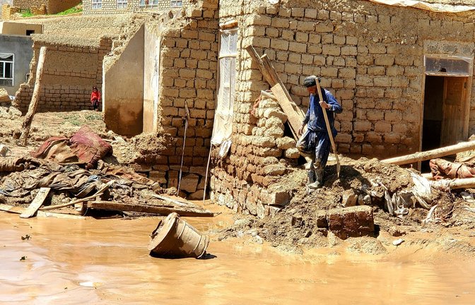 Ein Mann sammelt nach schweren Überschwemmungen in der Provinz Ghor seine Habseligkeiten zusammen.<span class='image-autor'>Foto: Omid Haqjoo/AP/dpa</span>