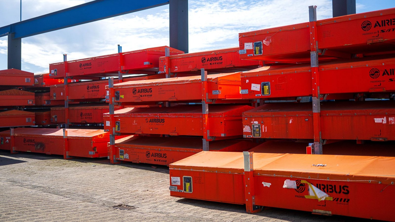 Vor der Werkhalle warten beschädigte Fahrzeugteile auf die Reparatur.Foto: Sina Schuldt/dpa