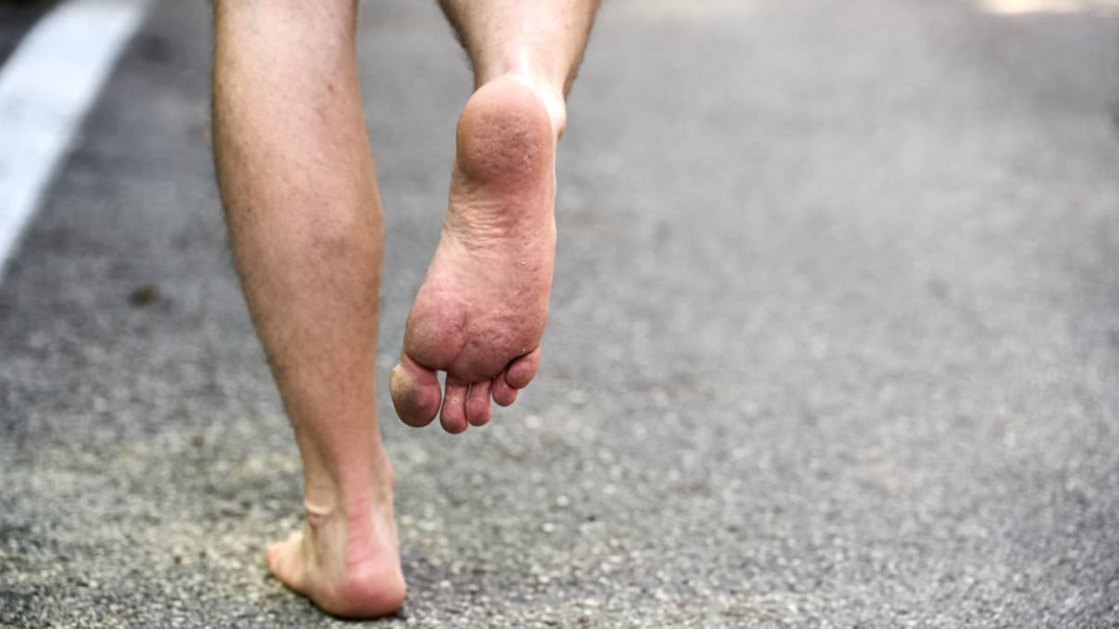 Eine Person läuft barfuß, also ohne Schuhe, auf einem gepflasterten Weg läuft, wodurch der direkte Hautkontakt mit der Erde betont wird und Abdrücke im Fuß in der Haut sichtbar sind. Barfußlaufen fördert die natürliche Verbindung zur Natur und bietet ein Gefühl von Freiheit und Entspannung und ist gut für die Gesundheit und Durchblutung.Imago/Bihlmayerfotografie Eine Person läuft barfuß, also ohne Schuhe, auf einem gepflasterten Weg läuft, wodurch der direkte Hautkontakt mit der Erde betont wird und Abdrücke im Fuß in der Haut sichtbar sind. Barfußlaufen fördert die natürliche Verbindung zur Natur und bietet ein Gefühl von Freiheit und Entspannung und ist gut für die Gesundheit und Durchblutung.Imago/Bihlmayerfotografie