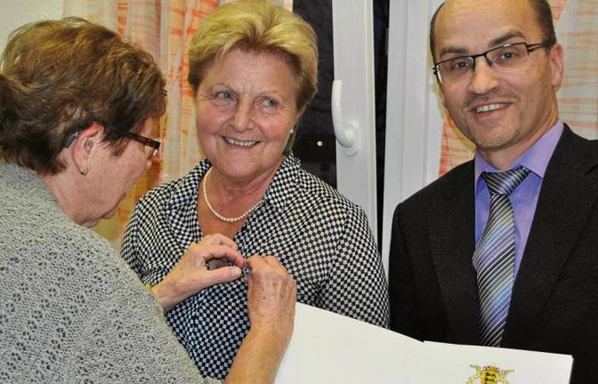 Wegbegleiterin Gertrud Hopf steckt Elfriede Sturm die Landesehrennadel an. Daneben: Bürgermeister Harald Eiberger.  Foto: Stahlfeld