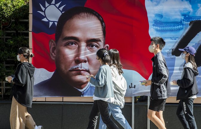 Passanten gehen an einem Plakat von Sun Yat-sen, dem ehemaligen Präsidenten von China, in der Innenstadt von Taipeh vorbei. Der Ausgang der Präsidentschafts- und Parlamentswahl am 13. Januar 2024 dürfte auch deutlichen Einfluss auf China haben, das Taiwan weiterhin als Teil seines Territoriums betrachtet.<span class='image-autor'>Foto: Wiktor Dabkowski/ZUMA Press Wire/dpa</span>