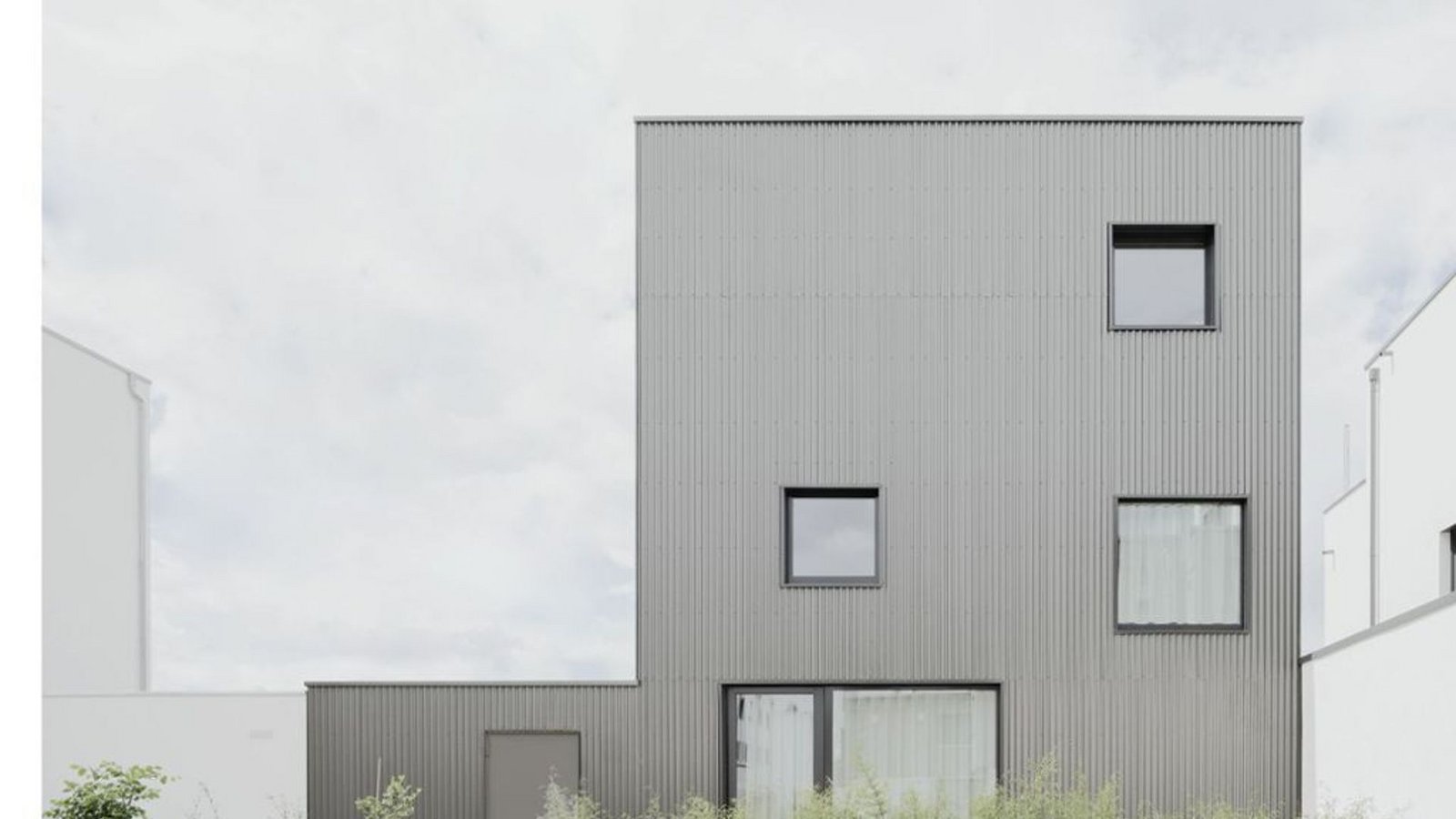 Das schwarze Schaf, so nennen der Architekt Stephan Birk und die Bauherren Katharina und Timm Berkmann scherzhaft das Einfamilienhaus in einer Neubausiedlung im Rems-Murr-Kreis. Der Vorschlag mit der Ummantelung kam vom Bauherren Timm Berkmann selbst: „Hier war früher eine Mineralwasserfabrik, und wir hatten die Idee, dass das Industrielle des Wellblechs eine schöne Anspielung an diese ehemalige Nutzung wäre.“Foto: Brigida González/Birk Heilmeyer und Frenzel Architekten Das schwarze Schaf, so nennen der Architekt Stephan Birk und die Bauherren Katharina und Timm Berkmann scherzhaft das Einfamilienhaus in einer Neubausiedlung im Rems-Murr-Kreis. Der Vorschlag mit der Ummantelung kam vom Bauherren Timm Berkmann selbst: „Hier war früher eine Mineralwasserfabrik, und wir hatten die Idee, dass das Industrielle des Wellblechs eine schöne Anspielung an diese ehemalige Nutzung wäre.“Foto: Brigida González/Birk Heilmeyer und Frenzel Architekten