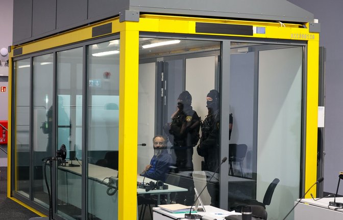 Von Spezialkräften der Justiz bewacht sitzt der Angeklagte in einer Glaskabine. (Archivbild)<span class='image-autor'>Foto: Peter Gercke/dpa</span>